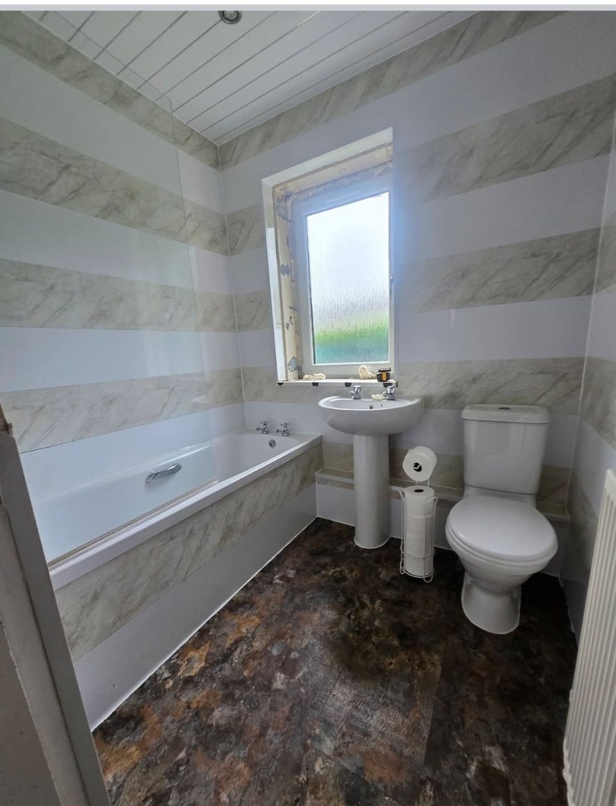 Bathroom finished with marble-effect wallboards, new bath and basin